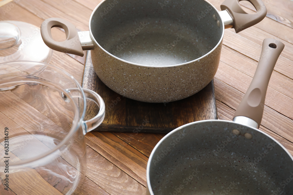 Cooking pots on wooden background, closeup