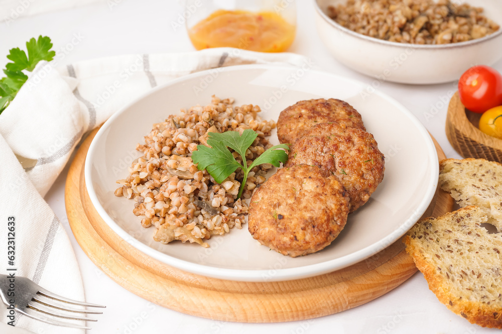 Cutlets with buckwheat, mushrooms and parsley on white table in kitchen