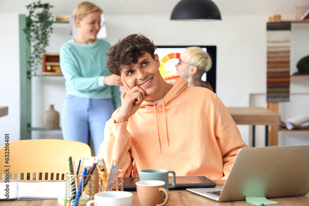 Thoughtful male graphic designer working at table in office