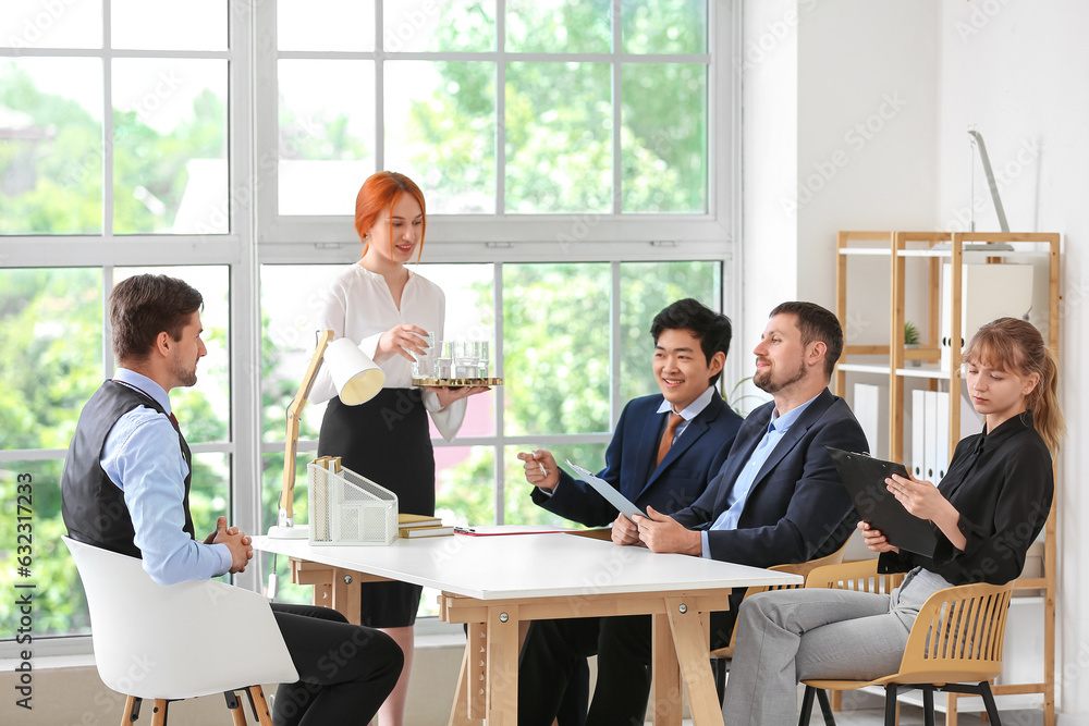 Secretary bringing water on job interview in office