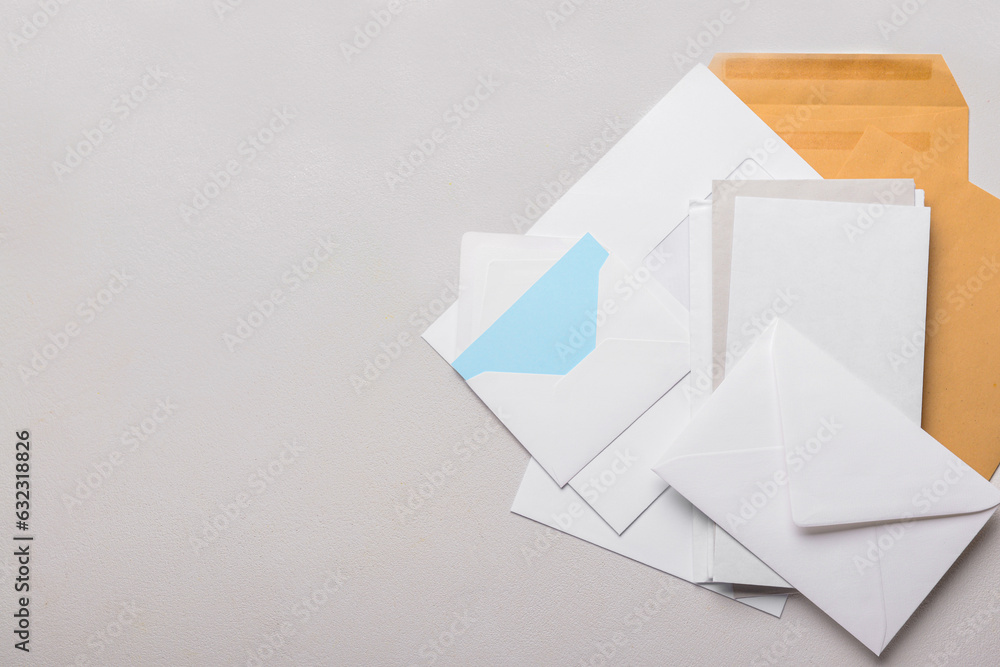 Heap of envelopes and card on light background