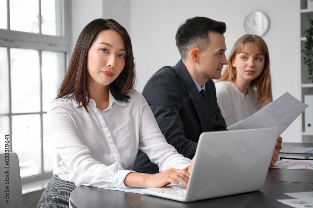 Female Asian business consultant working with laptop in office