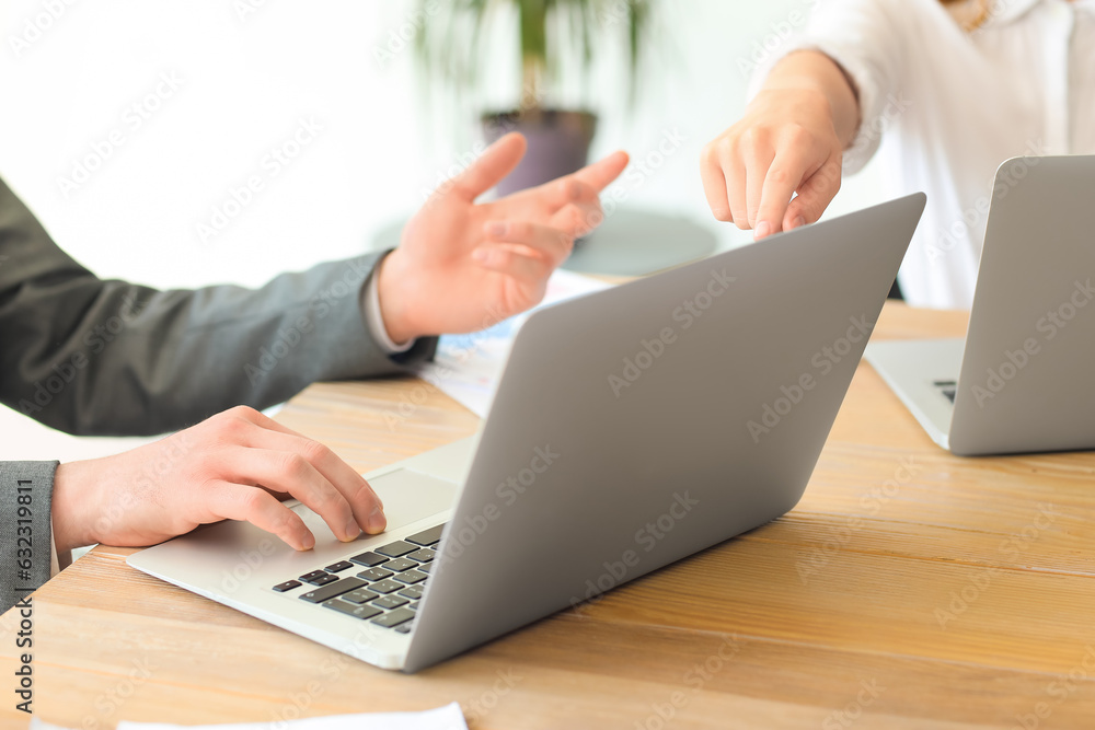 Male business consultant working with laptop at table in office, closeup