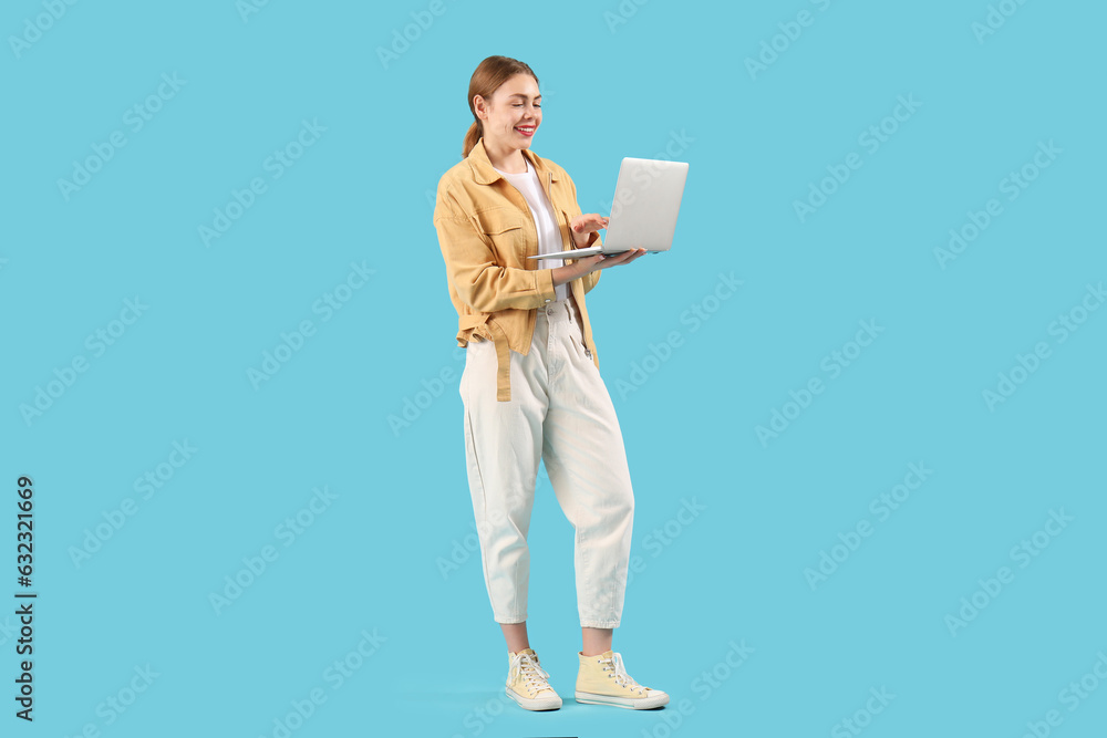 Female programmer working with laptop on blue background