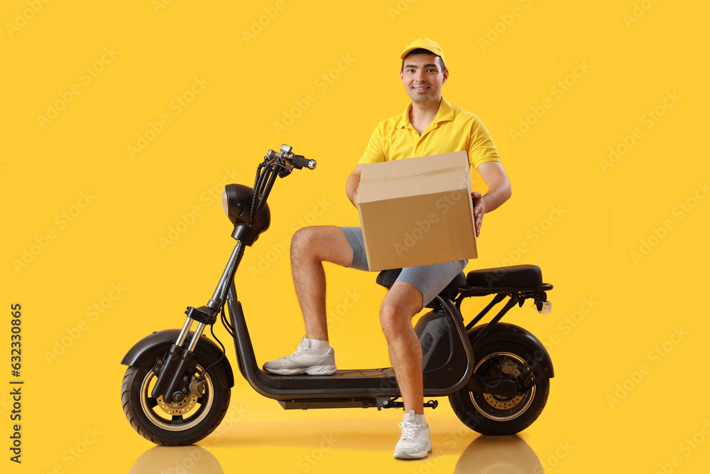 Male courier with parcel and bike on yellow background