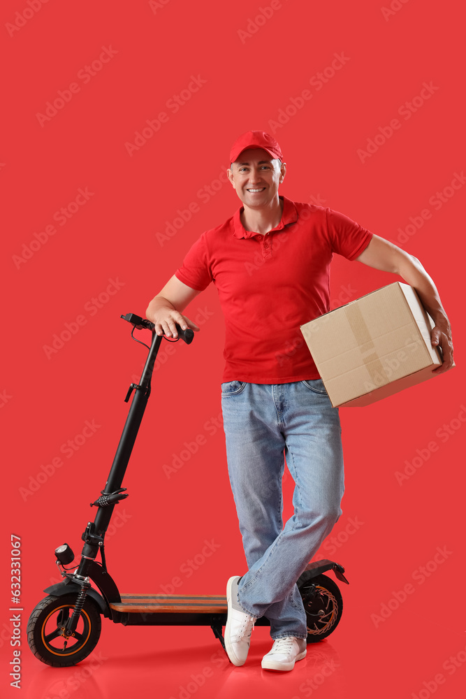 Mature courier with parcel and electric bike on red background