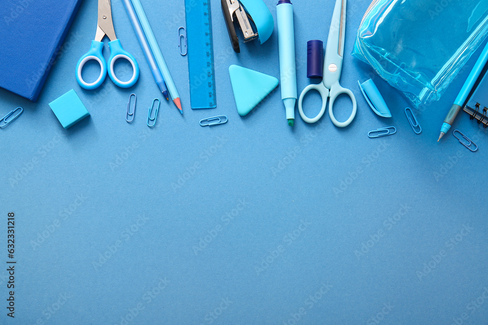 Different school stationery and notebooks on blue background