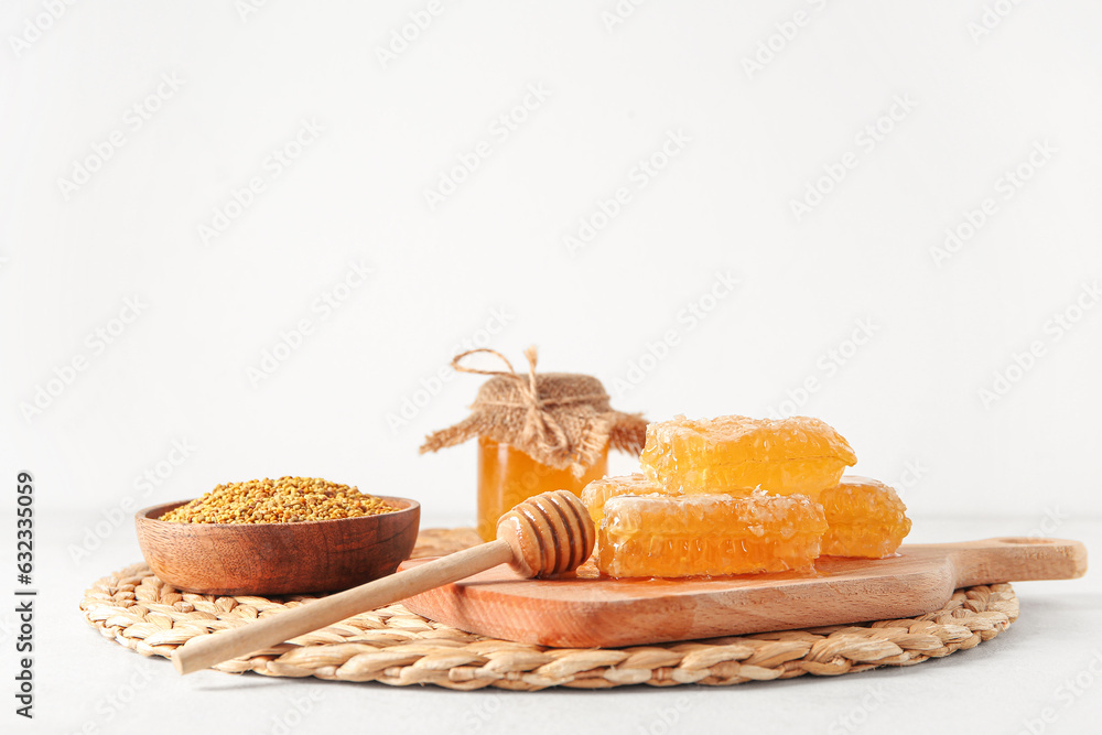 Composition with honey, combs and bee pollen on light background