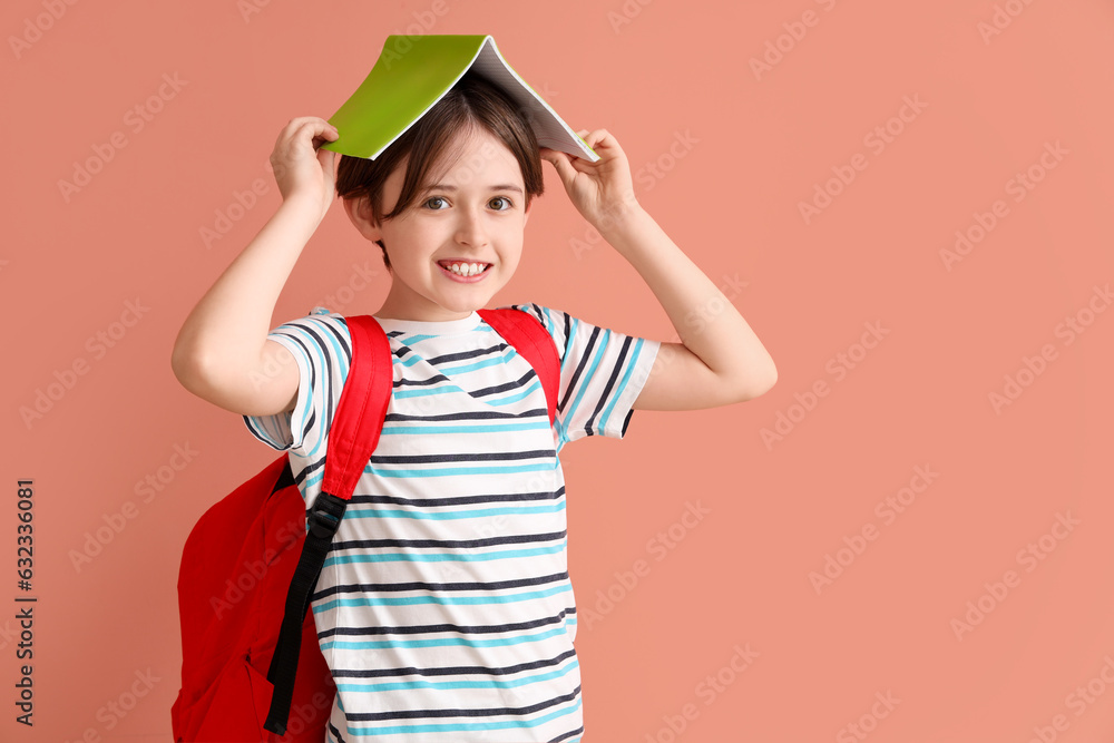 Little boy with backpack and notebook on color background