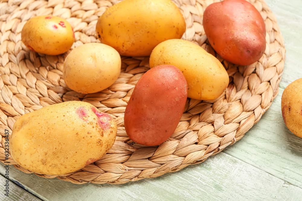 Fresh raw potatoes on green wooden background