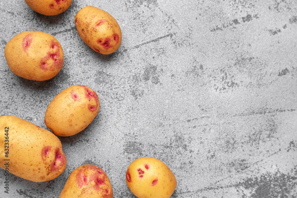 Fresh raw potatoes on blue background