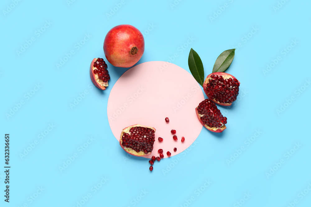 Blank card with fresh pomegranates and leaves on blue background