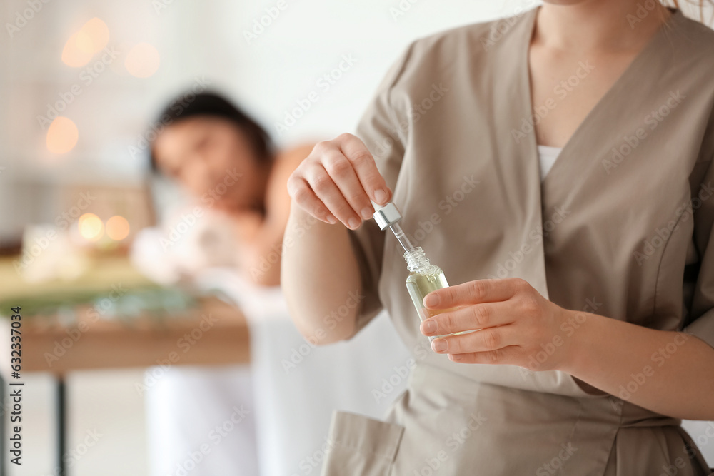 Young woman with essential oil in spa salon