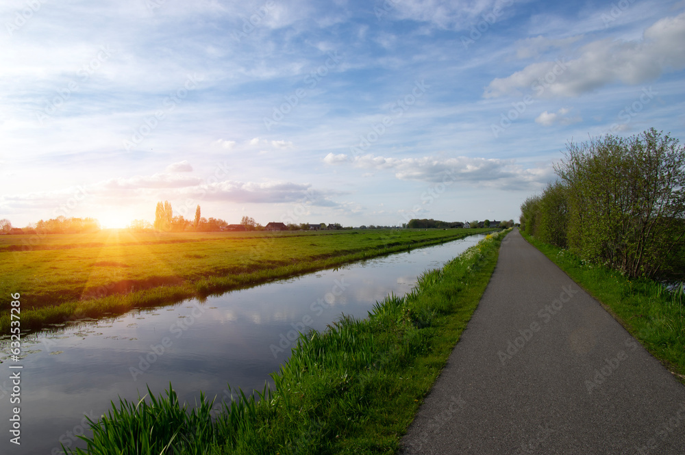 Landscape green meadow and canal with clear water