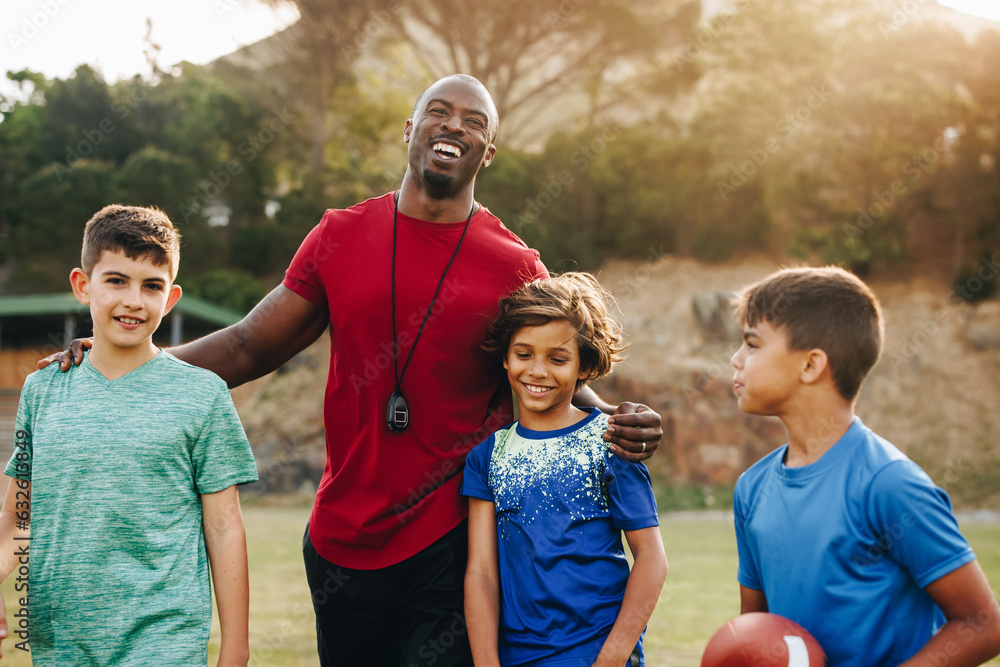 Primary school coach standing with his football team