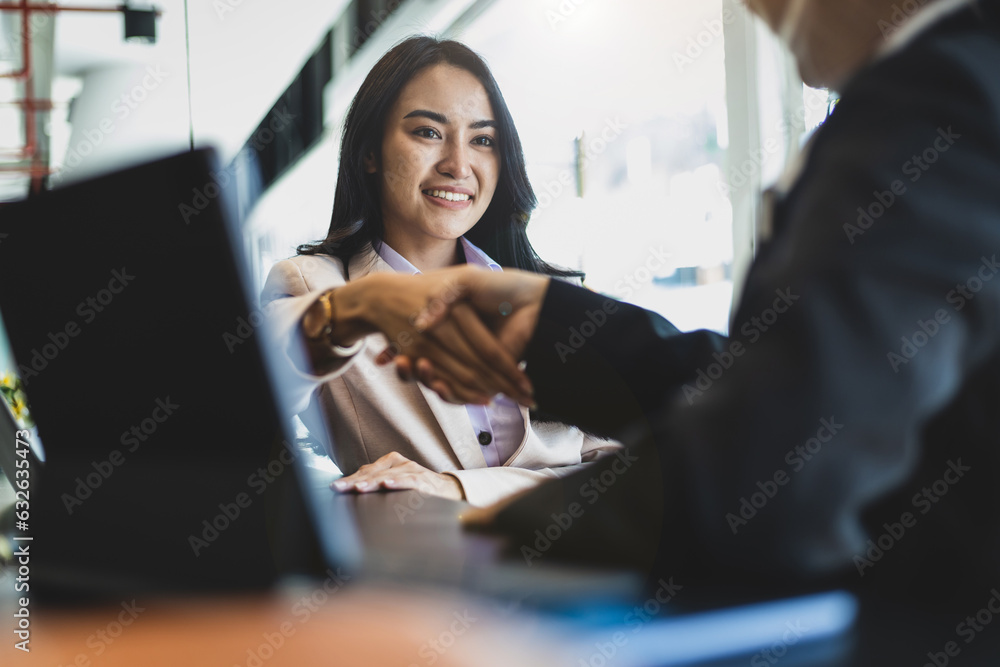 Partner, colleague, businesswoman shaking hands at business meeting, job interview.