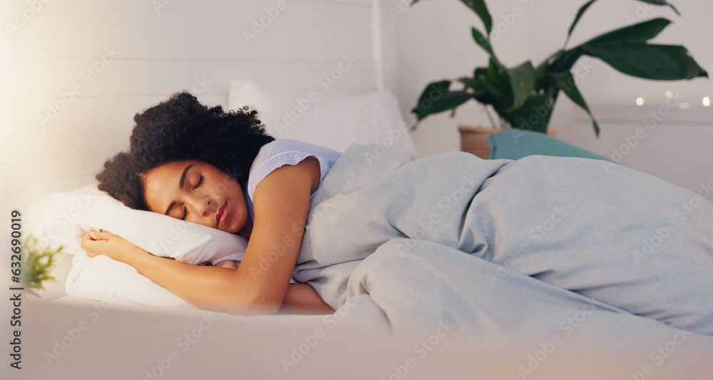 Young black woman sleeping in bed in her bedroom while resting and having a dream at home. Relax, pe