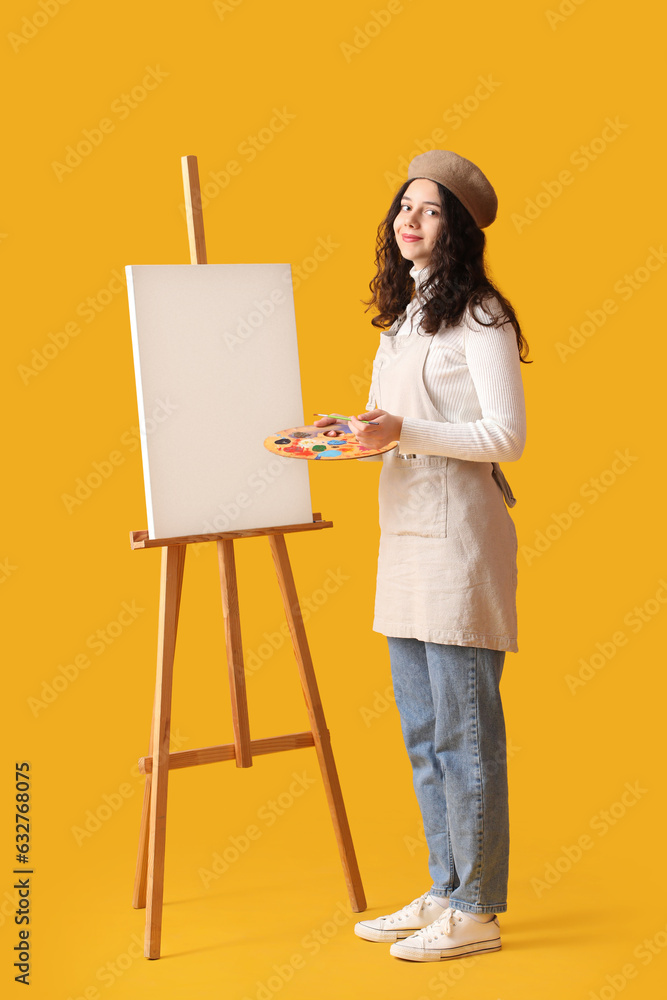 Teenage artist with brush, paint palette and easel on yellow background