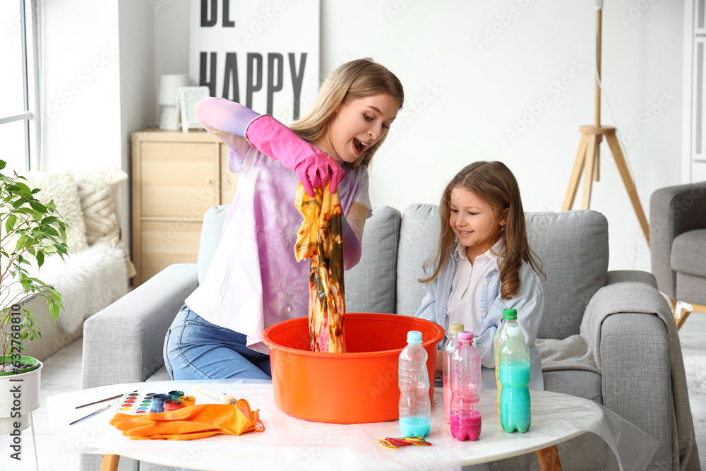 Little girl with her sister making tie-dye t-shirt at home