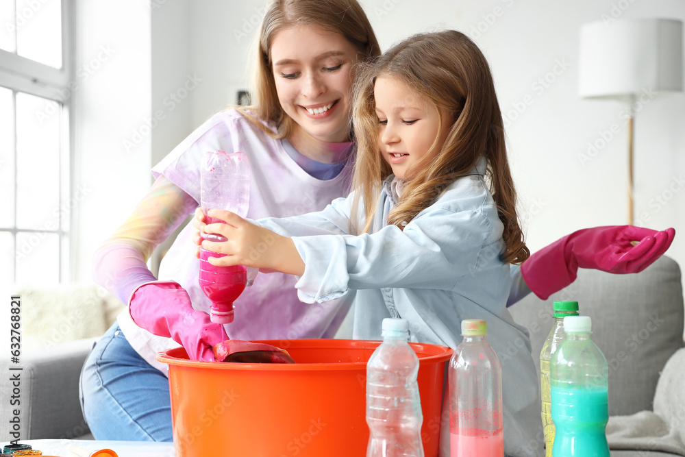 Little girl with her sister making tie-dye t-shirt at home