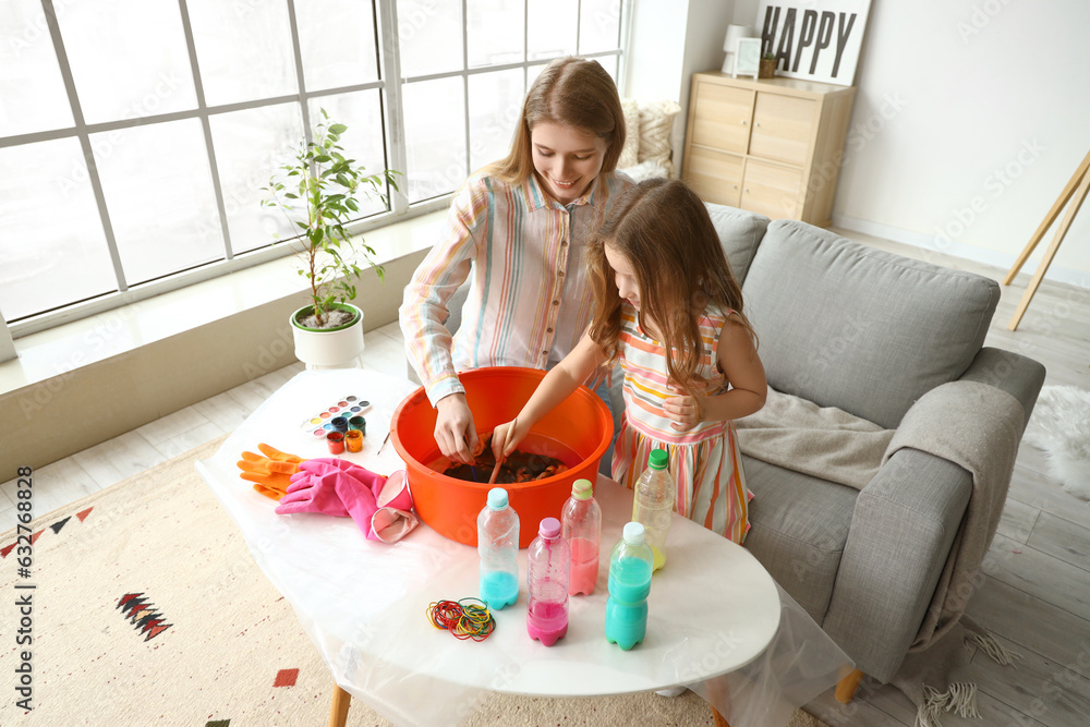 Little girl with her sister making tie-dye t-shirt at home