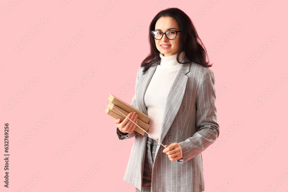 Literature teacher with books and pointer on pink background