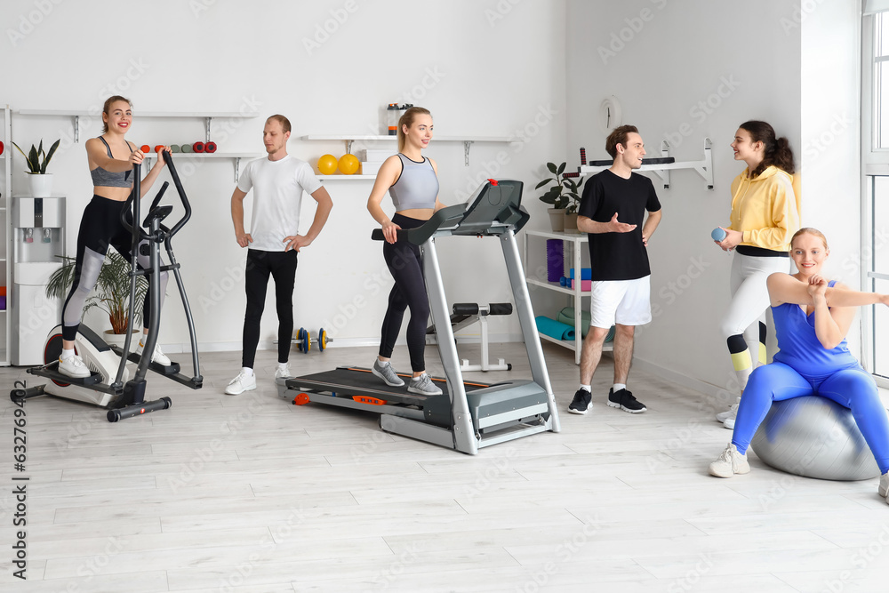 Group of sporty young people training in gym