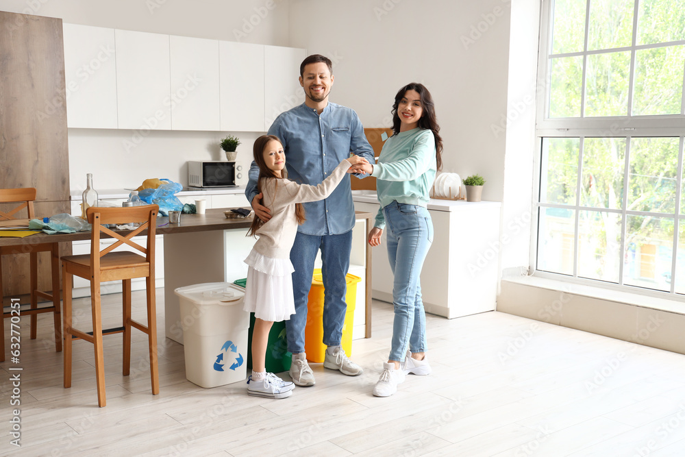 Family putting hands together while sorting garbage in kitchen