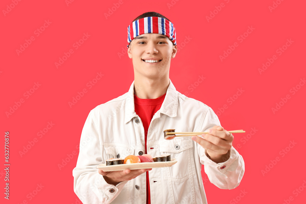 Young man with tasty sushi on red background