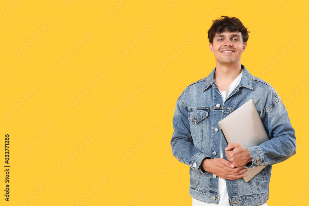 Male programmer with laptop on yellow background