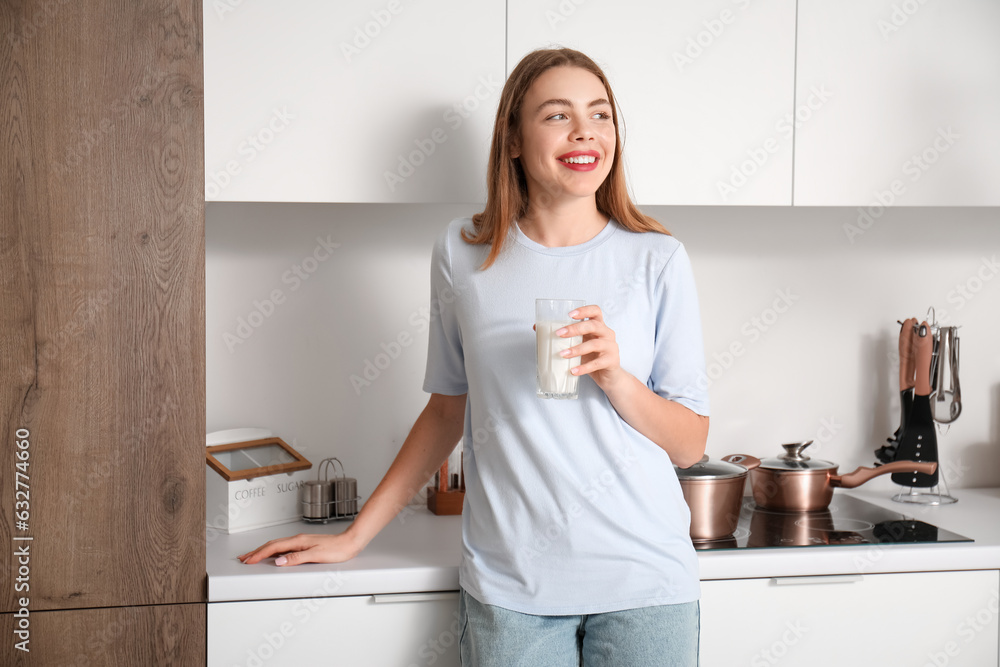 Young woman with glass of milk in kitchen