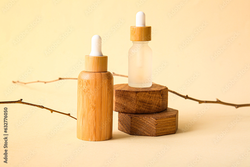 Composition with bottles of essential oil and plant branches on color background