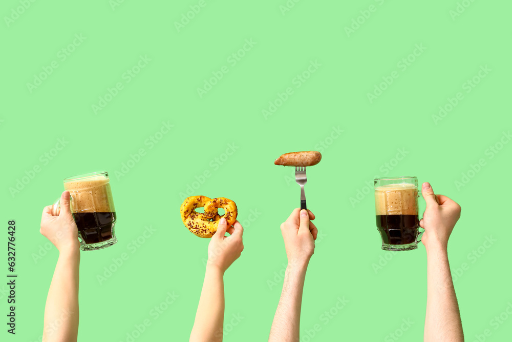 People with glasses of beer and snacks on green background