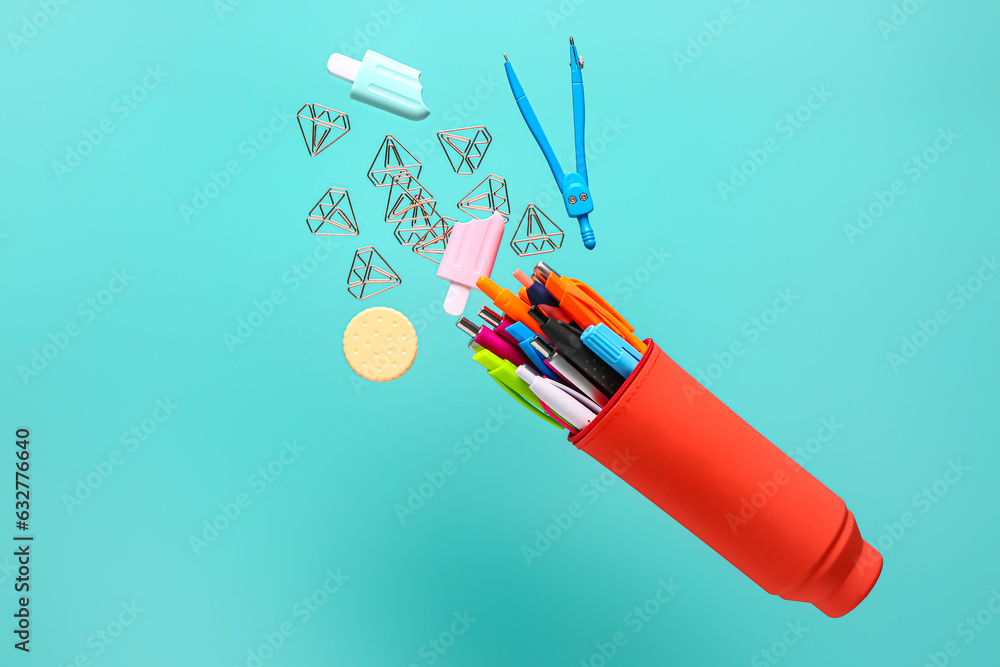 Flying pencil case with different stationery on color background