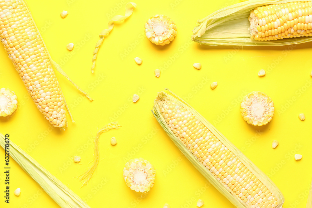 Fresh corn cobs and seeds on yellow background