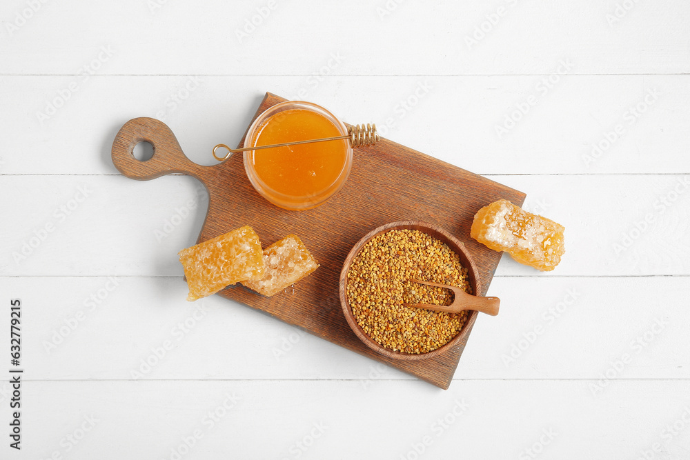 Kitchen board with jar of sweet honey, combs and bee pollen on light wooden background