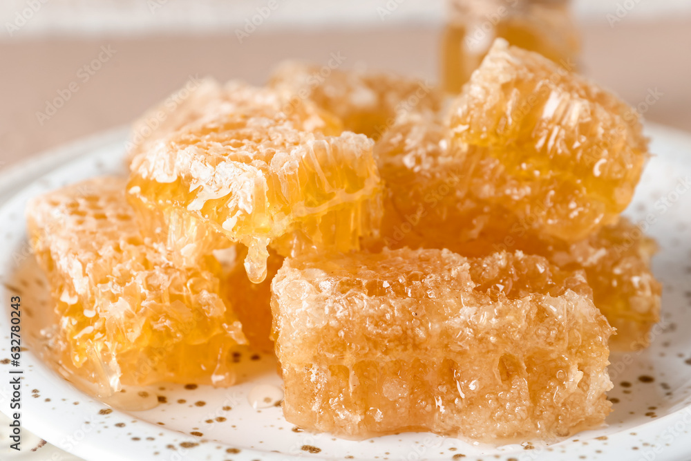 Plate with sweet honeycombs on table, closeup