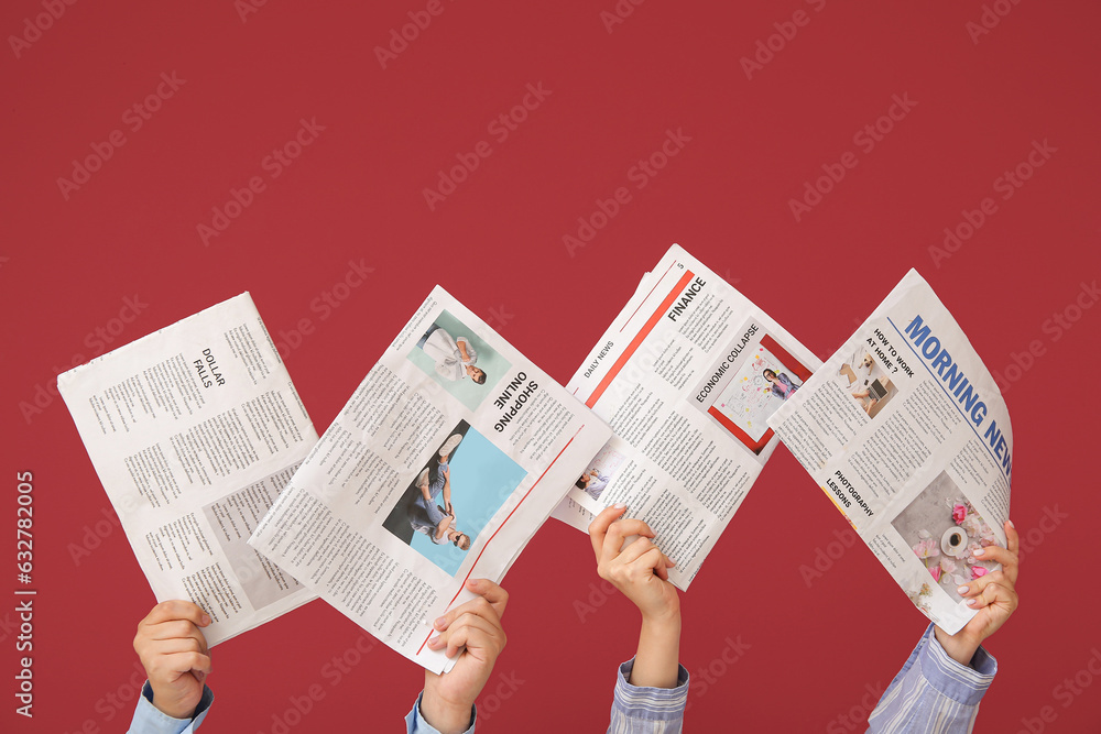 Women holding different newspapers on color background