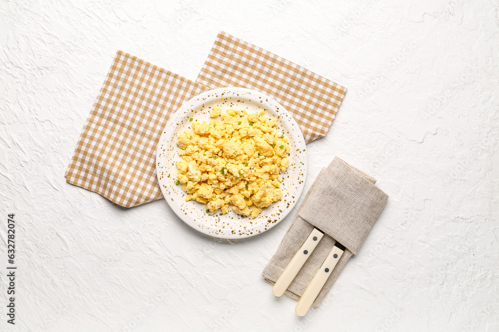 Plate of tasty scrambled eggs on white background