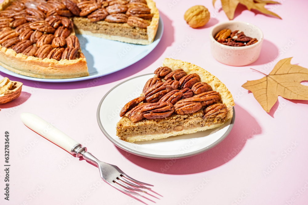 Plate with piece of tasty pecan pie on pink background