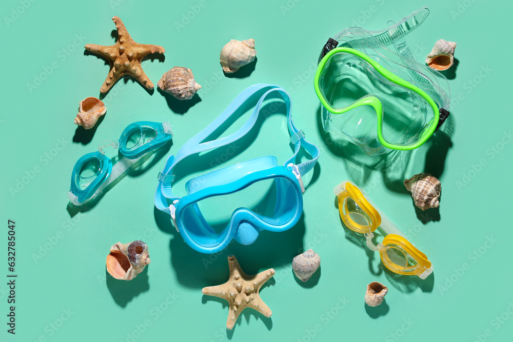 Composition with snorkeling masks, goggles and seashells on color background