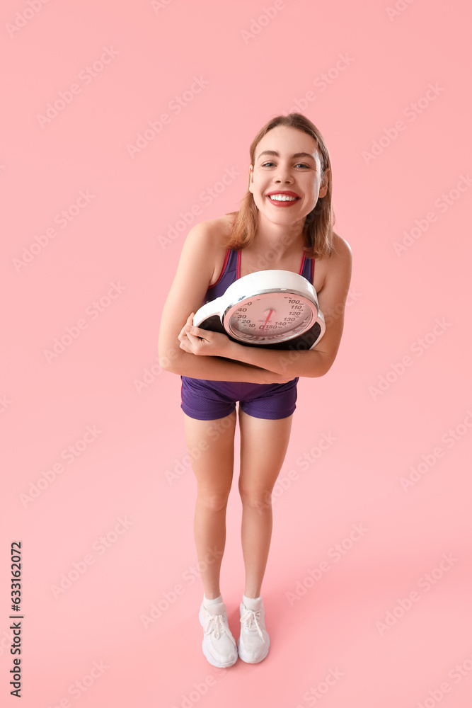 Happy young woman with scales on pink background