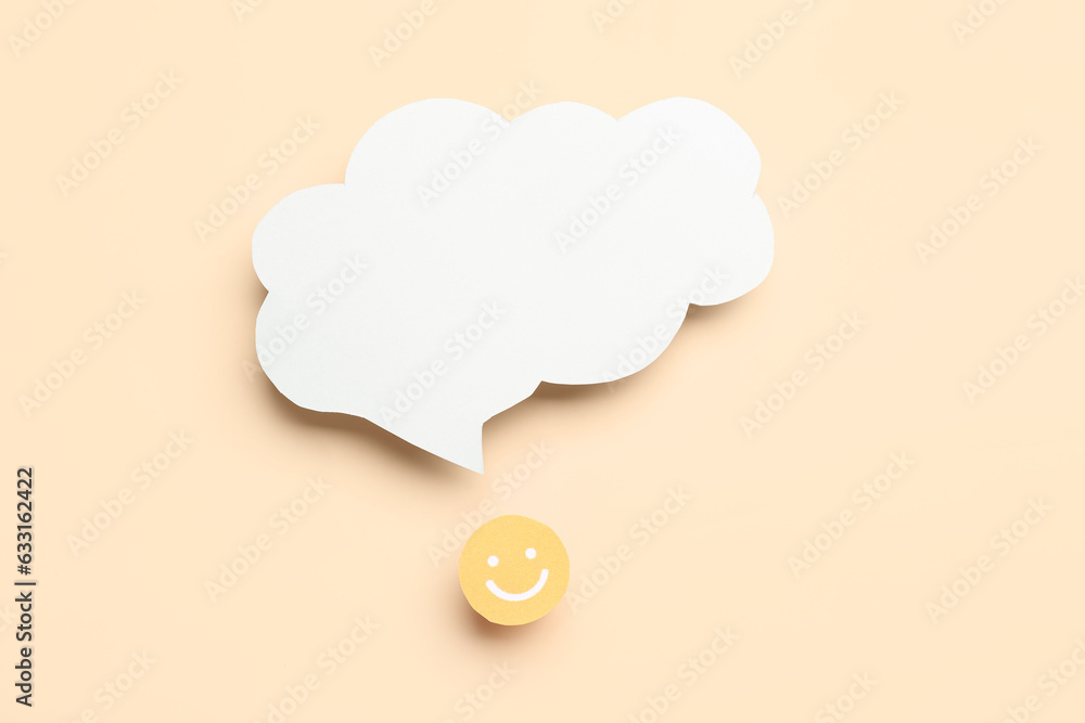 Paper face with blank speech bubble on beige background