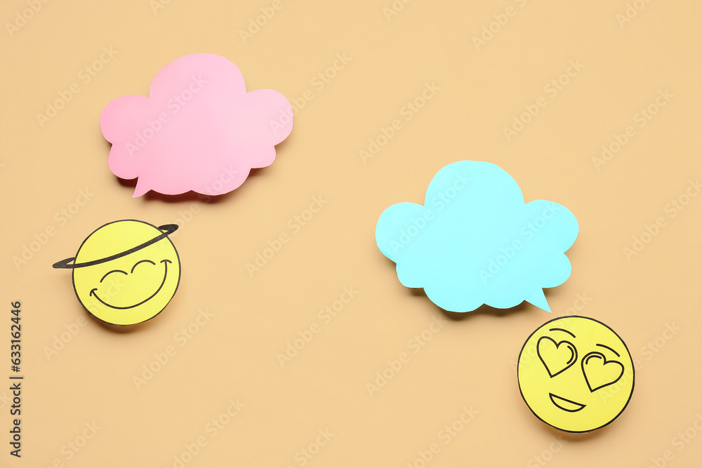 Paper faces with blank speech bubbles on beige background