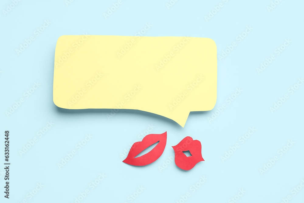 Paper lips with blank speech bubble on blue background