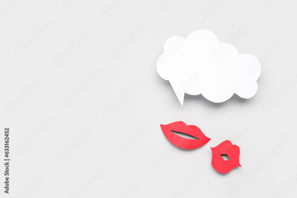 Paper lips with blank speech bubble on grey background