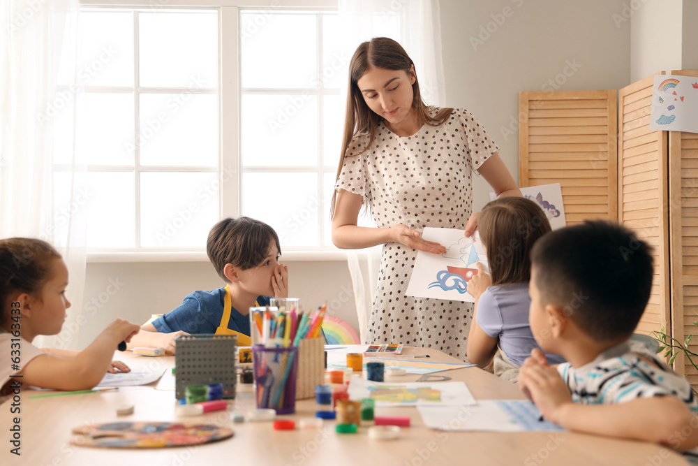 Little pupils with teacher in art class