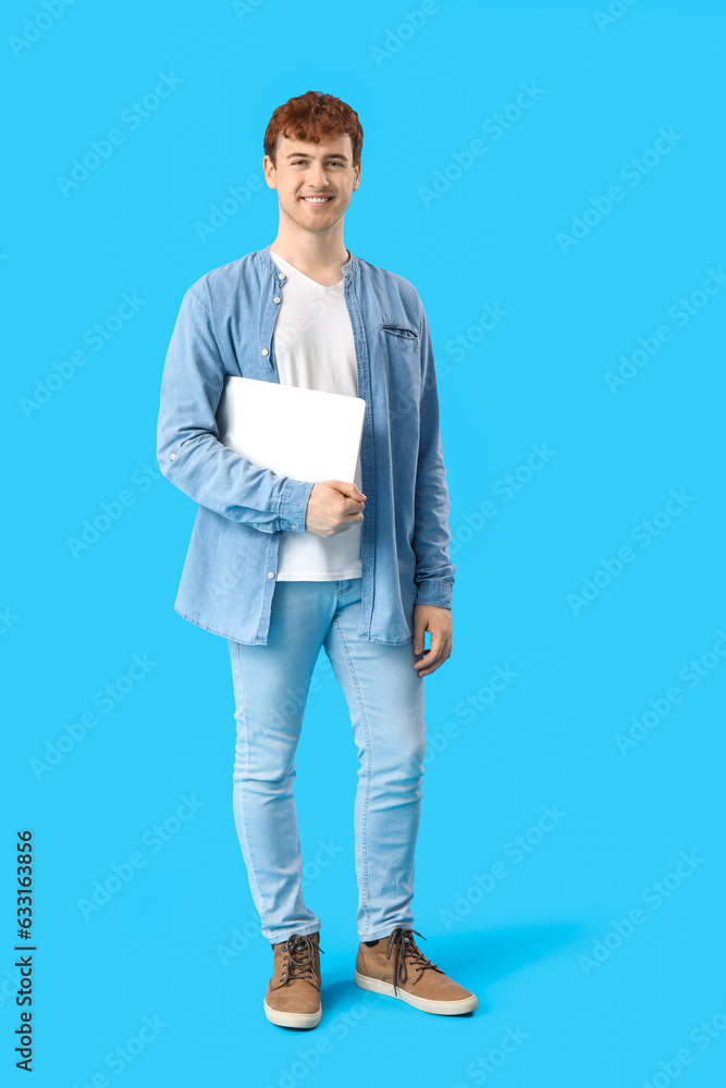 Male programmer with laptop on blue background