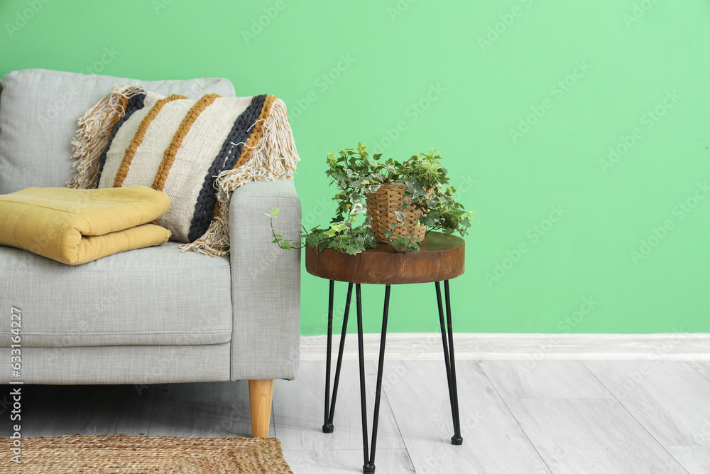 Interior of living room with folded plaid on sofa and table