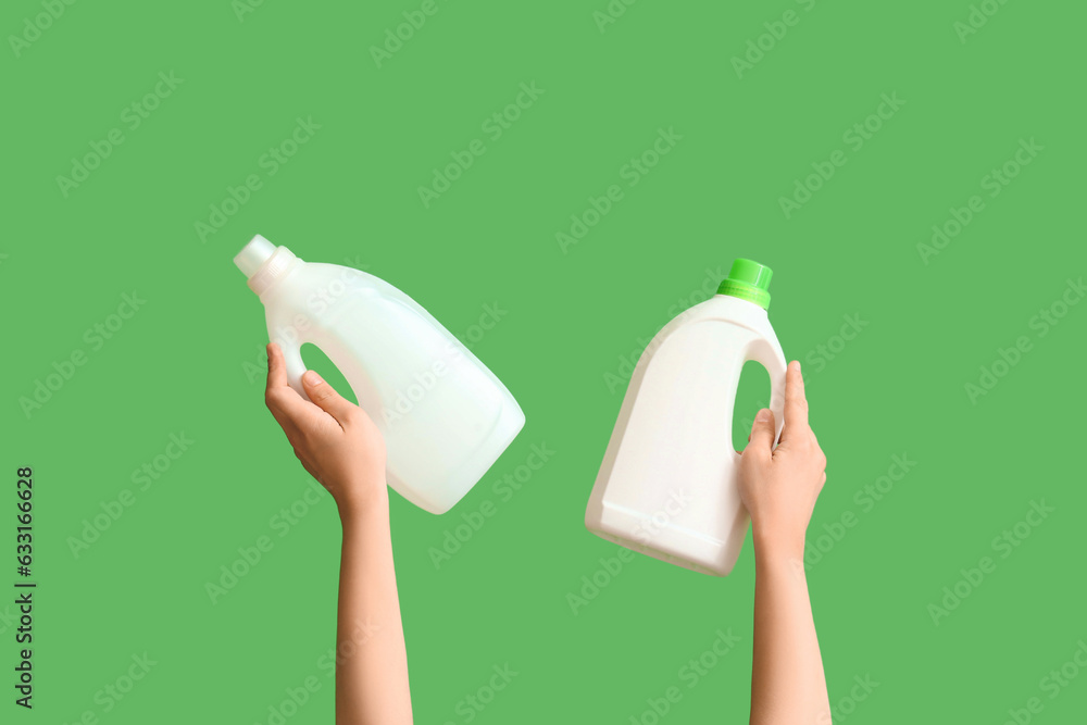 Woman with bottles of detergent on green background